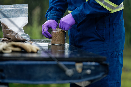 A closeup shot of the professional worker testing and sampling oil sands tailing ponds